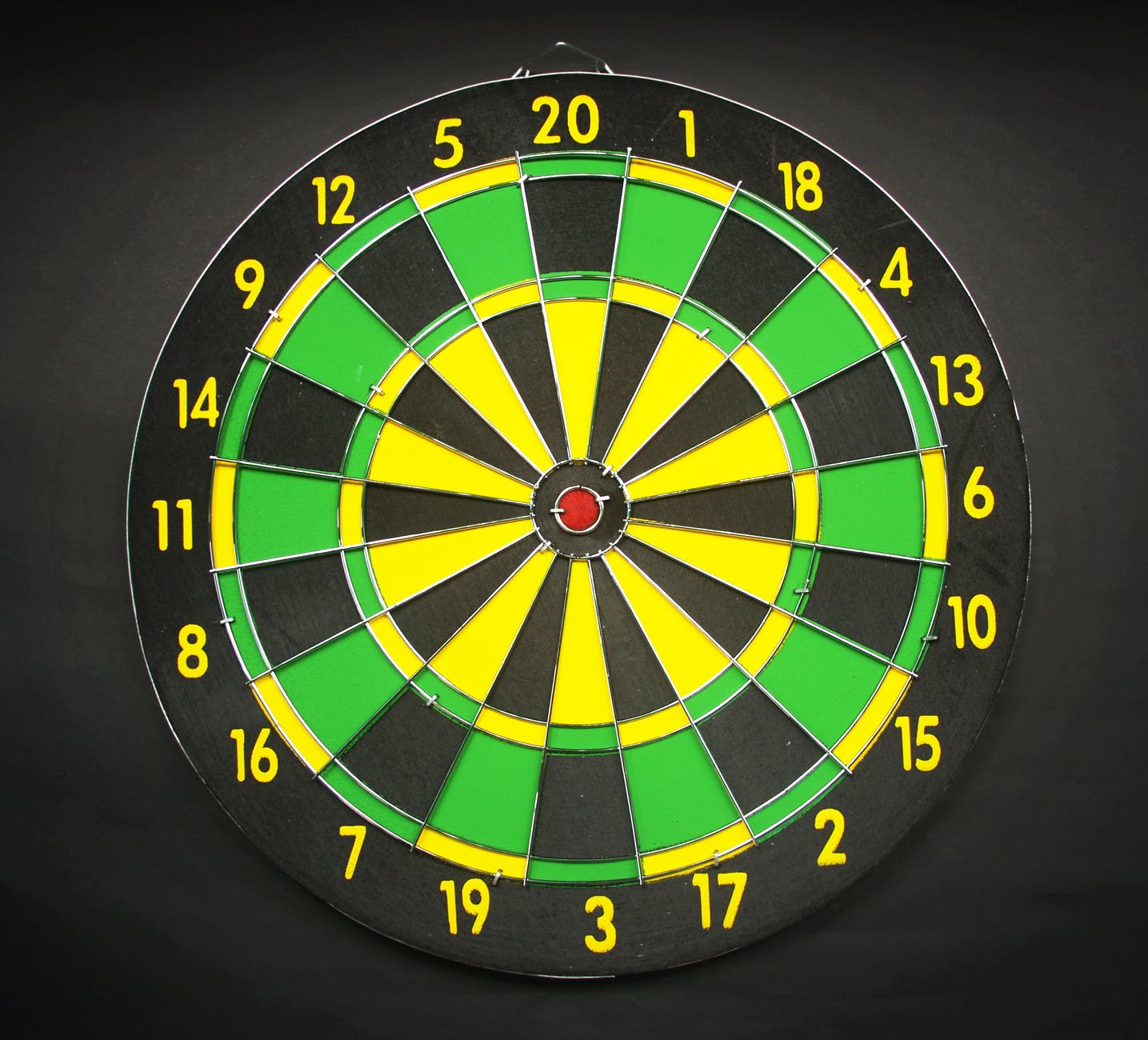 green yellow and black round dart board with black background