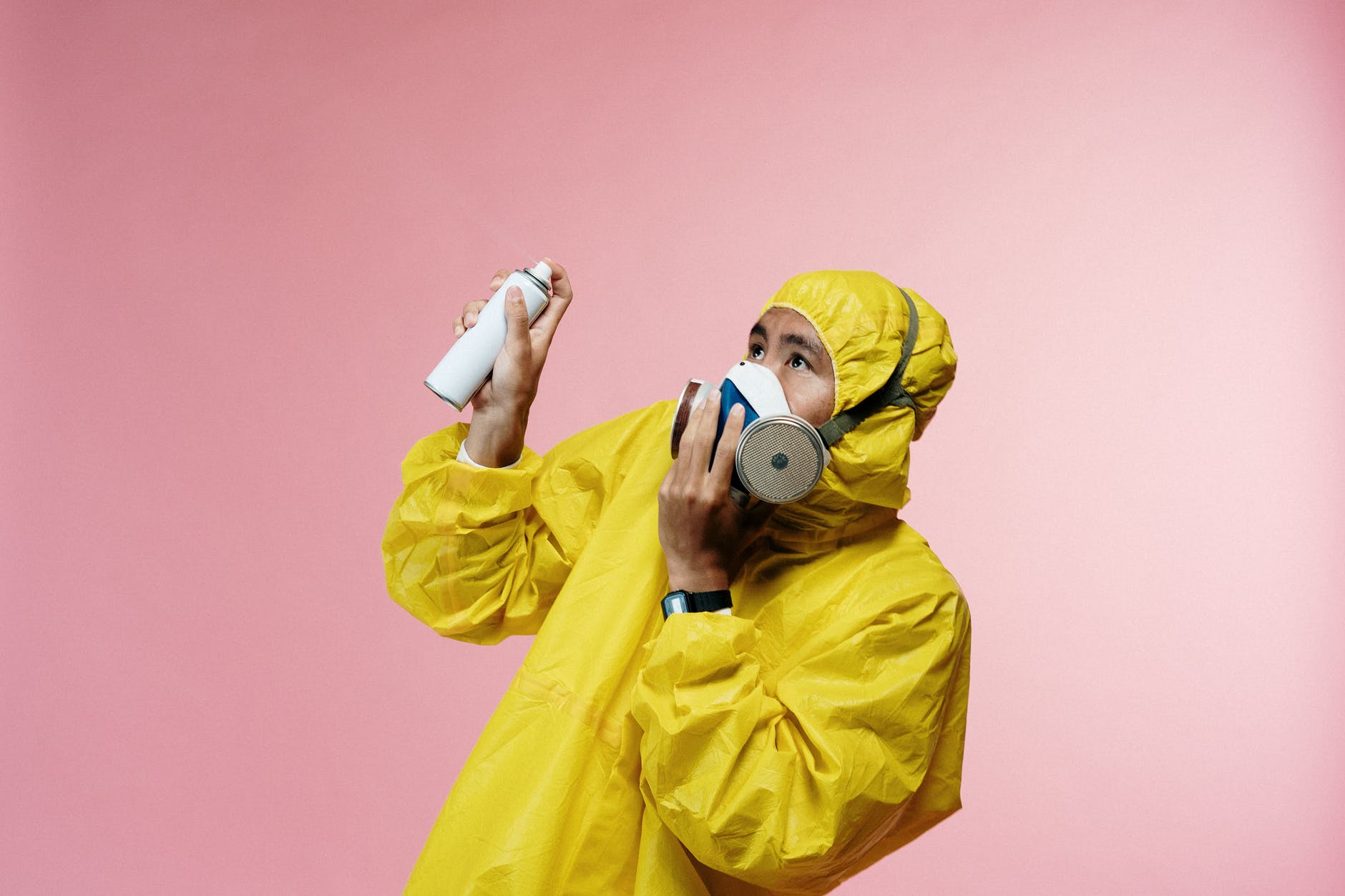 person in coveralls holding spray bottle